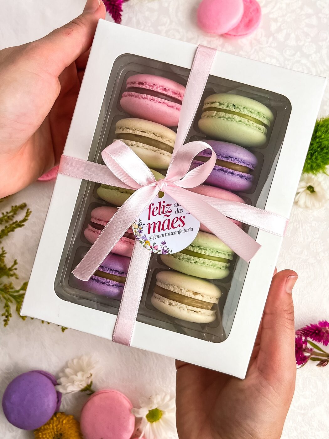 Caixa branca com dez macarons de sabores variados e fita rosa
